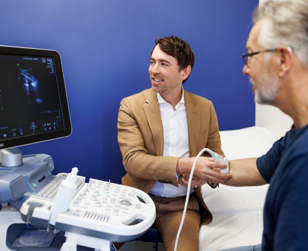 Dr Steel Scott ultrasounds a patient's arm at Holistic Imaging Geelong